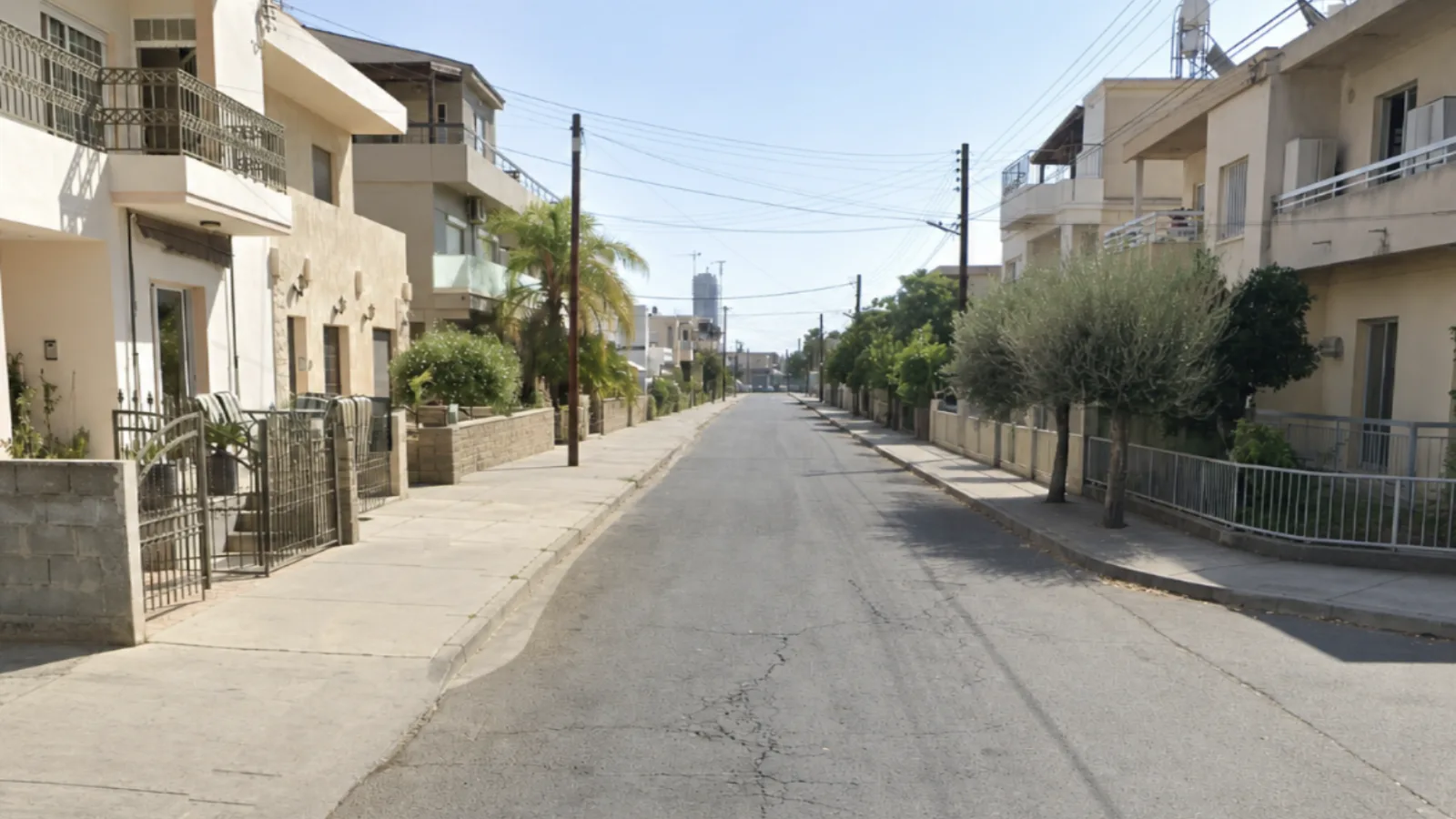 Ο ίδιος δρόμος από το ίδιο σημείο, με όλα τα παρκαρισμένα αυτοκίνητα σβησμένα: φαίνονται φαρδιά πεζοδρόμια και στις δύο πλευρές