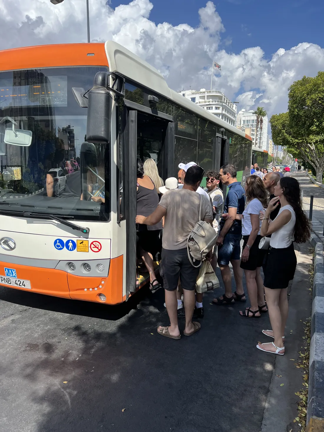 Люди заходят в низкопольный автобус прямо с асфальта: между автобусом и бордюром остаётся полоса проезжей части